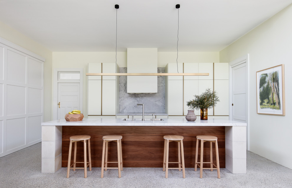 Idéer för ett modernt grå kök, med en dubbel diskho, släta luckor, granitbänkskiva, grått stänkskydd, betonggolv, en köksö och grått golv
