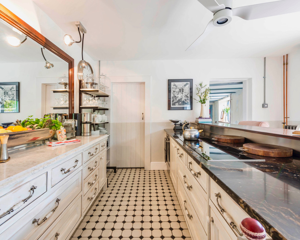 Cette image montre une cuisine parallèle bohème avec un placard avec porte à panneau encastré, des portes de placard blanches, une crédence blanche et un sol multicolore.