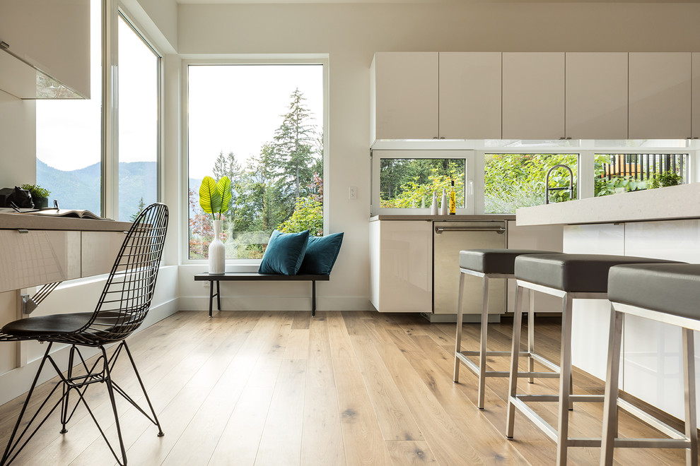 Expansive contemporary l-shaped kitchen/diner in Vancouver with a submerged sink, flat-panel cabinets, grey cabinets, quartz worktops, window splashback, stainless steel appliances, medium hardwood flooring, multiple islands and brown floors.