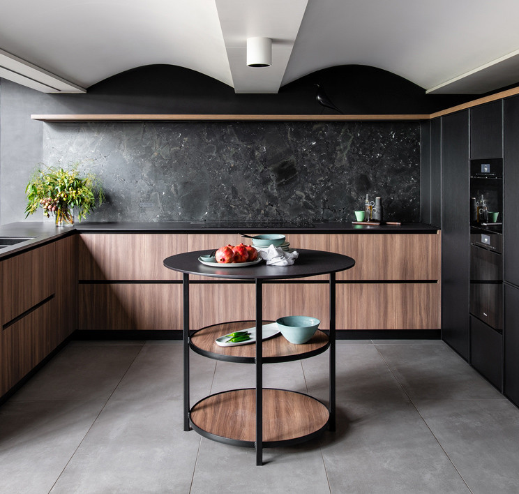 This is an example of a medium sized modern u-shaped open plan kitchen in Sydney with a submerged sink, recessed-panel cabinets, black splashback, stone slab splashback, black appliances, porcelain flooring, an island, black worktops and a wood ceiling.