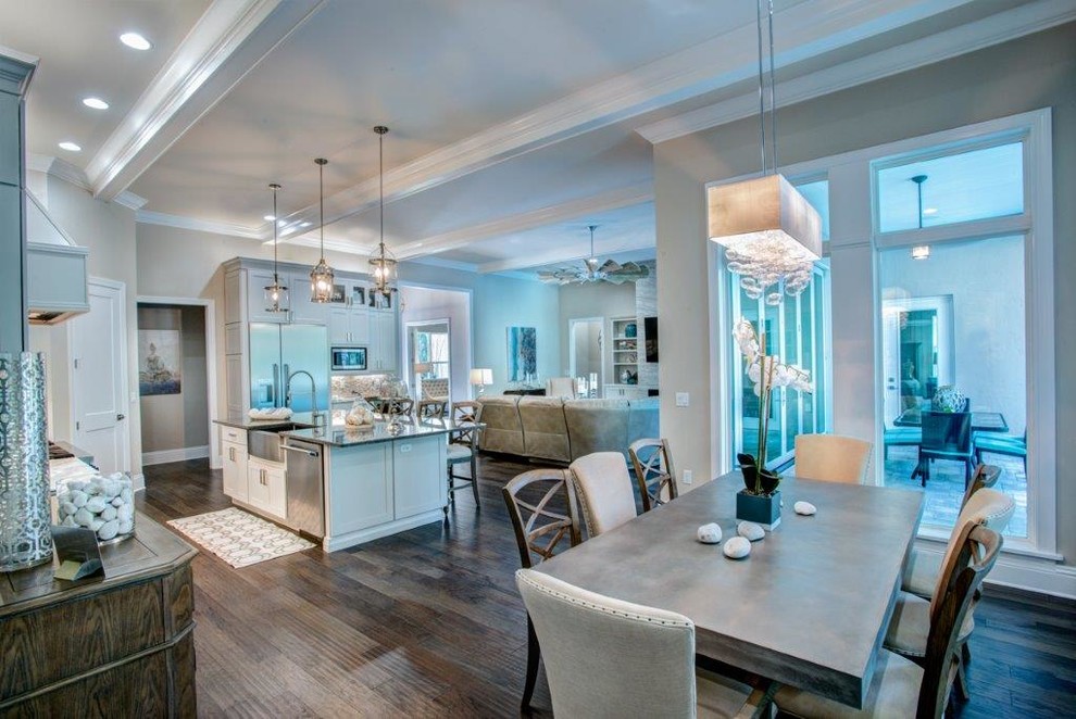 Inspiration for a large transitional l-shaped medium tone wood floor and brown floor open concept kitchen remodel in Orlando with a farmhouse sink, recessed-panel cabinets, white cabinets, quartzite countertops, beige backsplash, glass tile backsplash, stainless steel appliances and an island