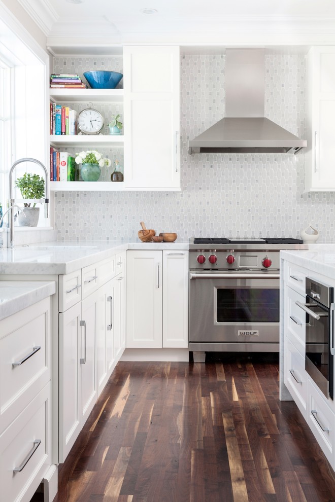 Large classic l-shaped kitchen/diner in Boston with white cabinets, white splashback, stainless steel appliances, dark hardwood flooring, a submerged sink, recessed-panel cabinets, mosaic tiled splashback and an island.