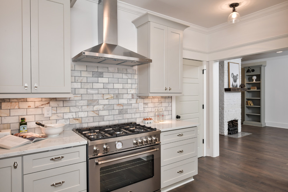 Inspiration for a medium sized classic kitchen in Atlanta with a belfast sink, shaker cabinets, grey cabinets, engineered stone countertops, white splashback, marble splashback, stainless steel appliances, light hardwood flooring, no island, brown floors and white worktops.