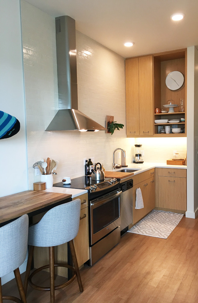Design ideas for a small contemporary galley kitchen in Portland with a submerged sink, flat-panel cabinets, light wood cabinets, quartz worktops, white splashback, ceramic splashback, stainless steel appliances, vinyl flooring and no island.