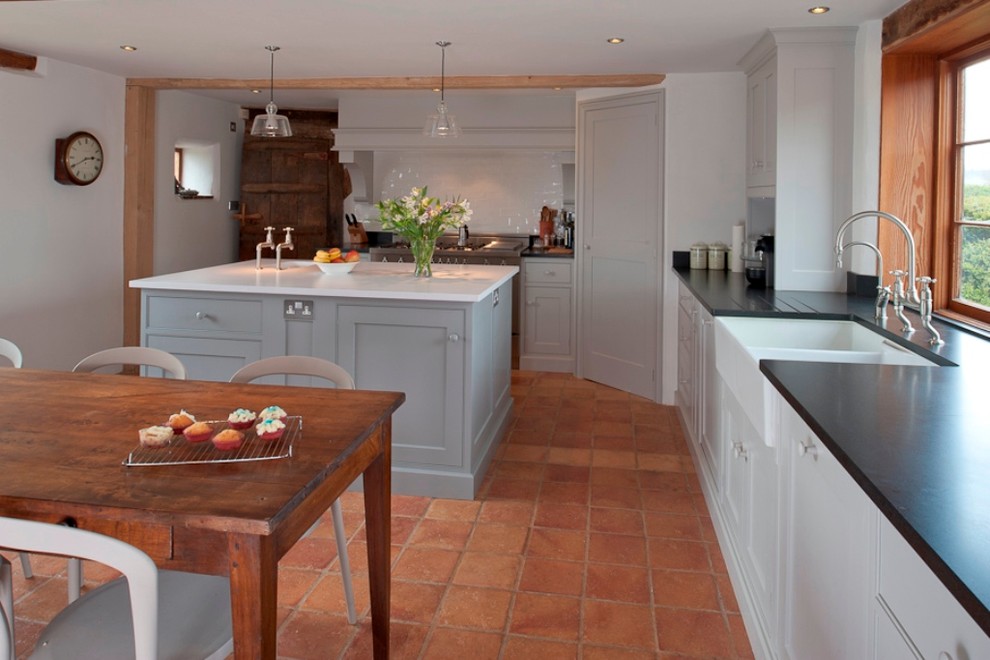 Urige Küche mit Schrankfronten mit vertiefter Füllung, Landhausspüle, grauen Schränken und Mauersteinen in Kent
