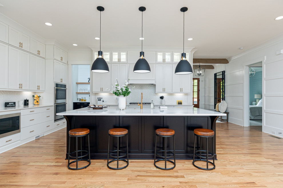 Exempel på ett stort amerikanskt vit vitt kök, med en rustik diskho, skåp i shakerstil, svarta skåp, bänkskiva i kvartsit, vitt stänkskydd, stänkskydd i cementkakel, rostfria vitvaror, mellanmörkt trägolv, en köksö och brunt golv