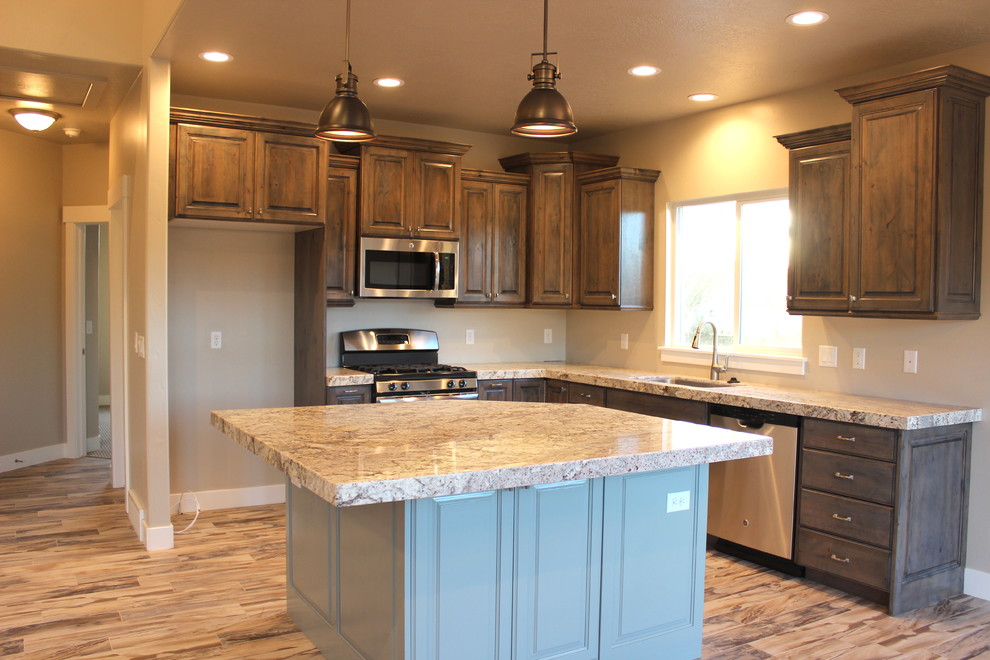 This is an example of a large classic galley kitchen/diner in Salt Lake City with a submerged sink, raised-panel cabinets, grey cabinets, granite worktops, stainless steel appliances, medium hardwood flooring and an island.