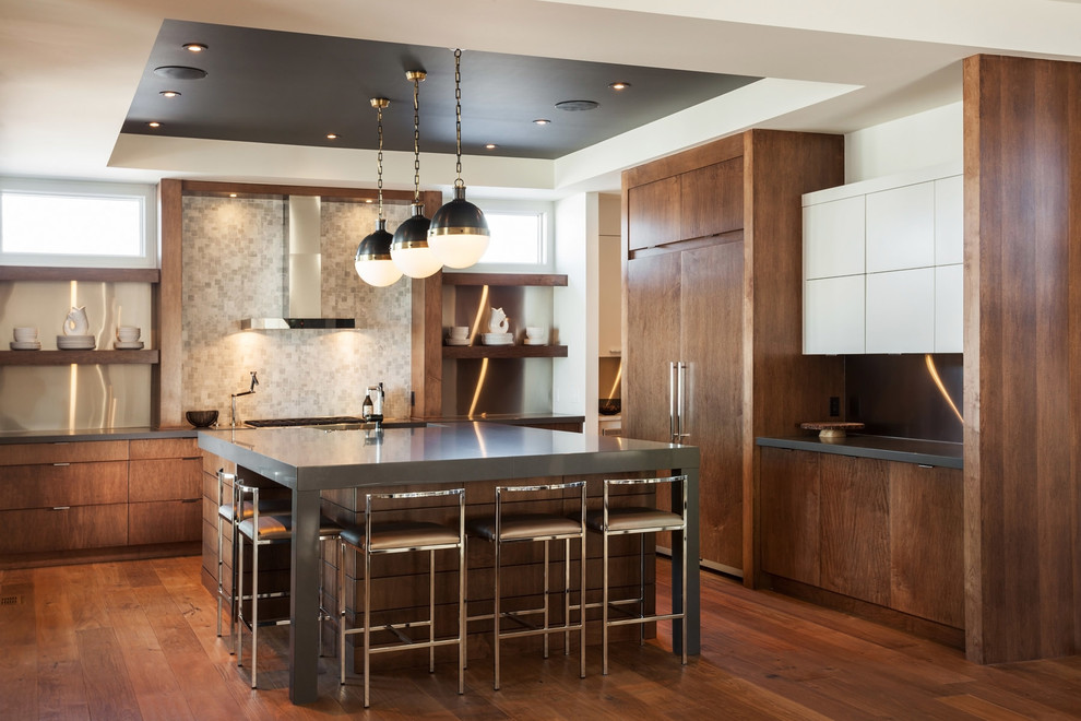 Cette photo montre une cuisine encastrable tendance en bois brun avec un placard à porte plane, une crédence grise, un sol en bois brun et îlot.