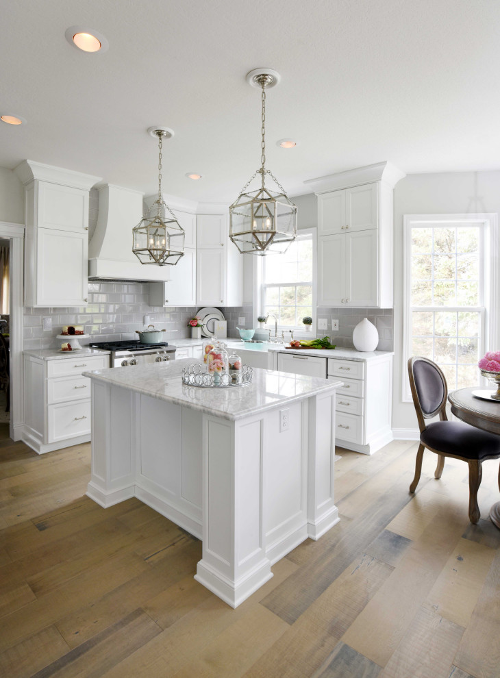 Bild på ett mellanstort vintage vit vitt kök, med en rustik diskho, skåp i shakerstil, vita skåp, marmorbänkskiva, grått stänkskydd, stänkskydd i tunnelbanekakel, rostfria vitvaror, mellanmörkt trägolv, en köksö och brunt golv