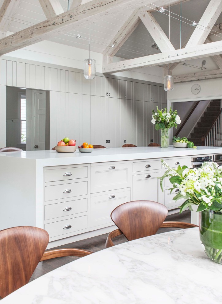 Example of a farmhouse dark wood floor eat-in kitchen design in Boston with recessed-panel cabinets, white cabinets and an island