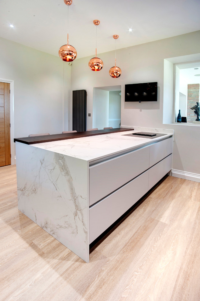 This is an example of a modern kitchen in Other with flat-panel cabinets and engineered stone countertops.