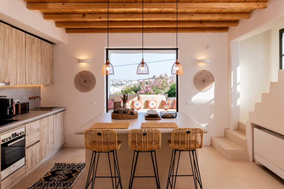 Foto di una cucina mediterranea con ante lisce, ante in legno chiaro, elettrodomestici in acciaio inossidabile, pavimento beige, top grigio, travi a vista e soffitto in legno