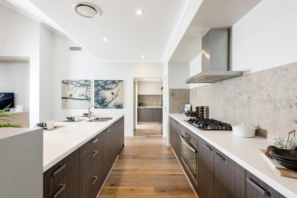 This is an example of a contemporary galley kitchen in Perth with a double-bowl sink, flat-panel cabinets, dark wood cabinets, beige splashback and light hardwood flooring.