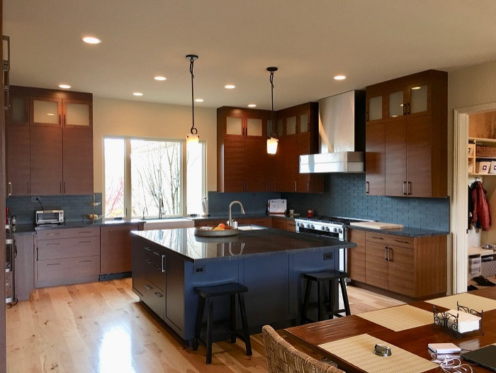 Idéer för att renovera ett stort orientaliskt grå grått kök, med en rustik diskho, släta luckor, skåp i mellenmörkt trä, bänkskiva i kvartsit, blått stänkskydd, stänkskydd i glaskakel, rostfria vitvaror, bambugolv, en köksö och brunt golv