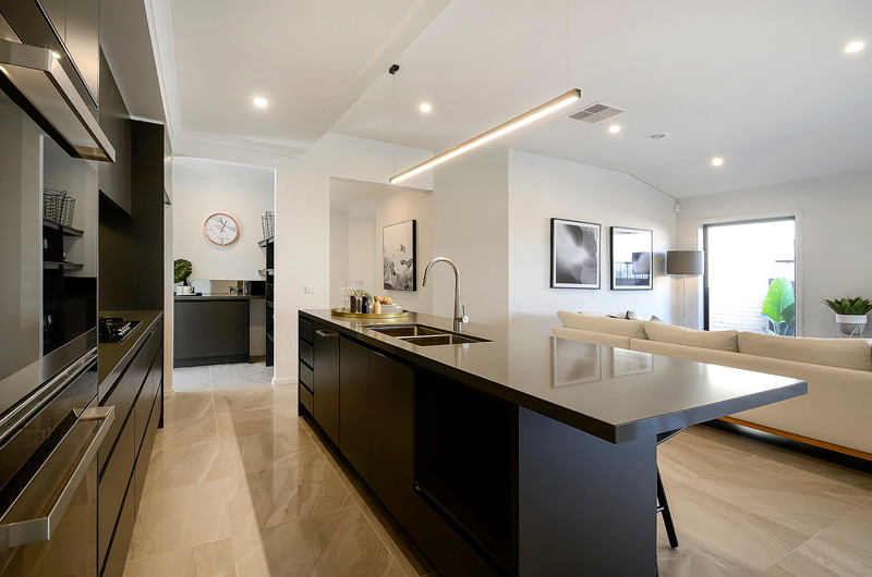 Example of a mid-sized minimalist galley brown floor open concept kitchen design in Melbourne with an undermount sink, brown cabinets, quartz countertops, mirror backsplash, stainless steel appliances, an island and brown countertops