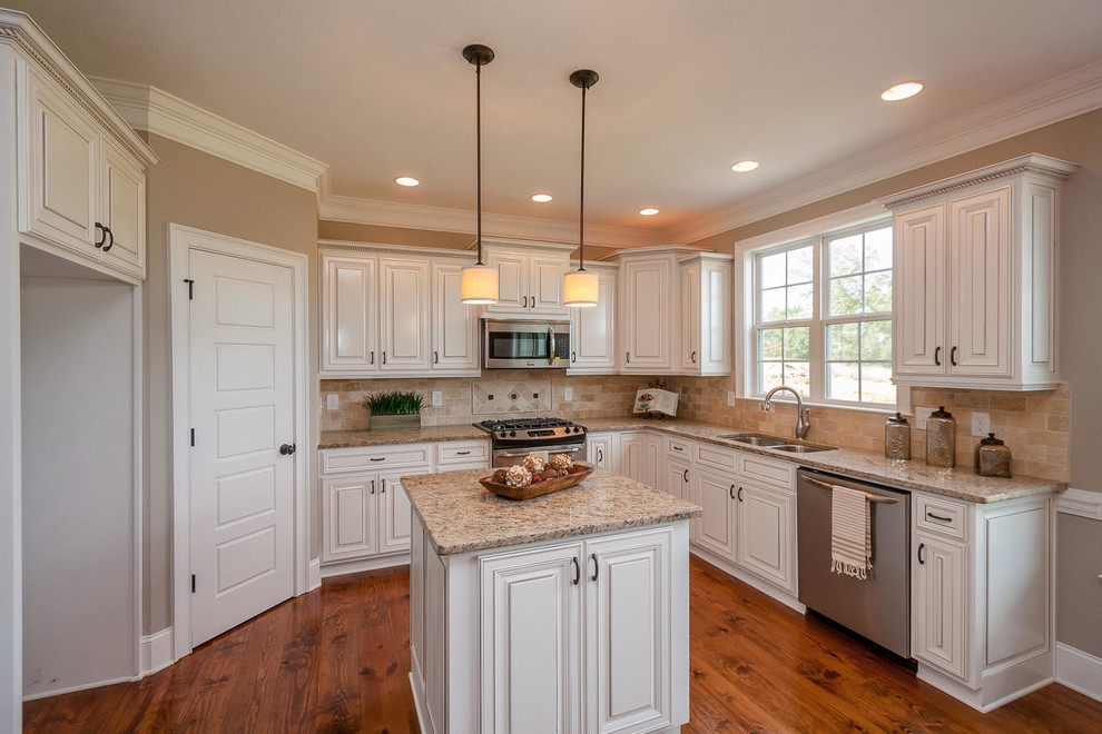 Mid-sized elegant l-shaped medium tone wood floor eat-in kitchen photo in Atlanta with an undermount sink, raised-panel cabinets, white cabinets, granite countertops, beige backsplash, stone tile backsplash, stainless steel appliances and an island