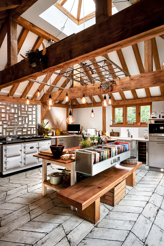 Bild på ett shabby chic-inspirerat kök, med en rustik diskho, släta luckor, grå skåp, en köksö och vitt golv