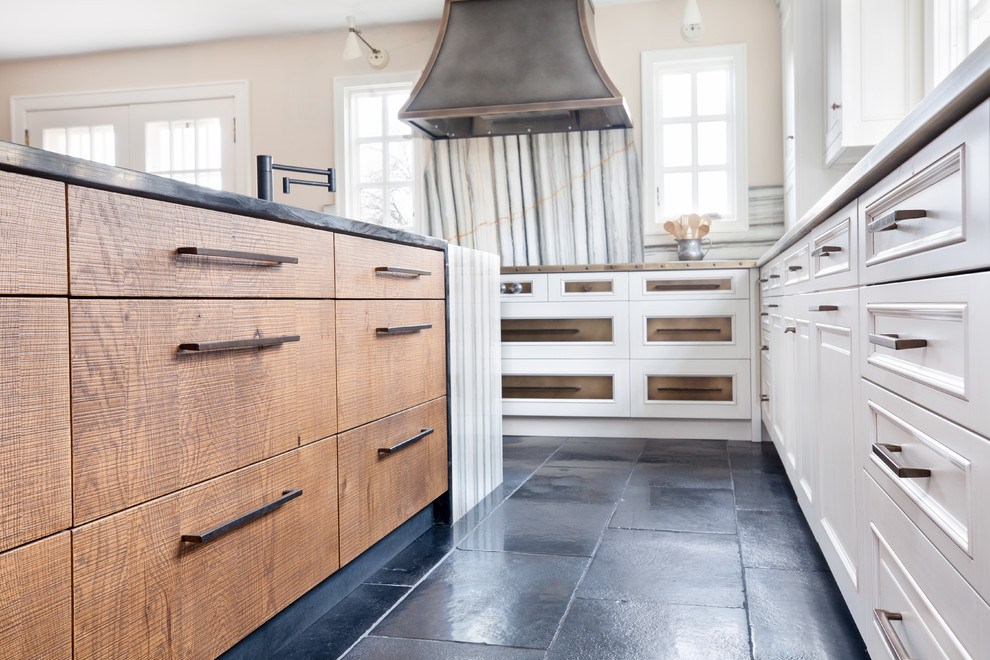 Foto de cocina ecléctica con armarios estilo shaker, electrodomésticos de acero inoxidable, una isla, encimeras negras y puertas de armario blancas
