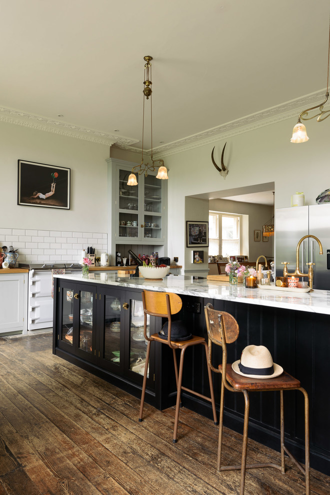 Große Stilmix Küche mit Schrankfronten im Shaker-Stil, braunem Holzboden, Halbinsel und braunem Boden in Sonstige