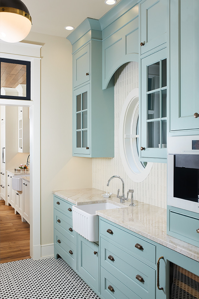This is an example of a medium sized traditional galley kitchen pantry in Grand Rapids with a belfast sink, shaker cabinets, blue cabinets, limestone worktops, white splashback, ceramic splashback, ceramic flooring, multi-coloured floors and beige worktops.