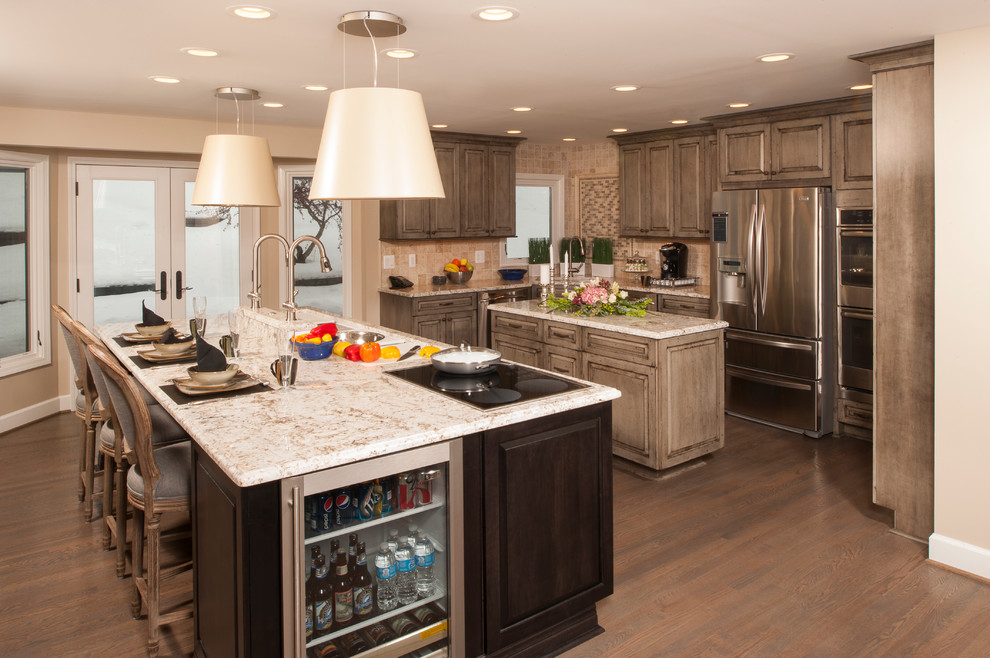 Eat-in kitchen - large traditional l-shaped medium tone wood floor eat-in kitchen idea in Detroit with a single-bowl sink, distressed cabinets, granite countertops, beige backsplash, stainless steel appliances, two islands, raised-panel cabinets and stone tile backsplash