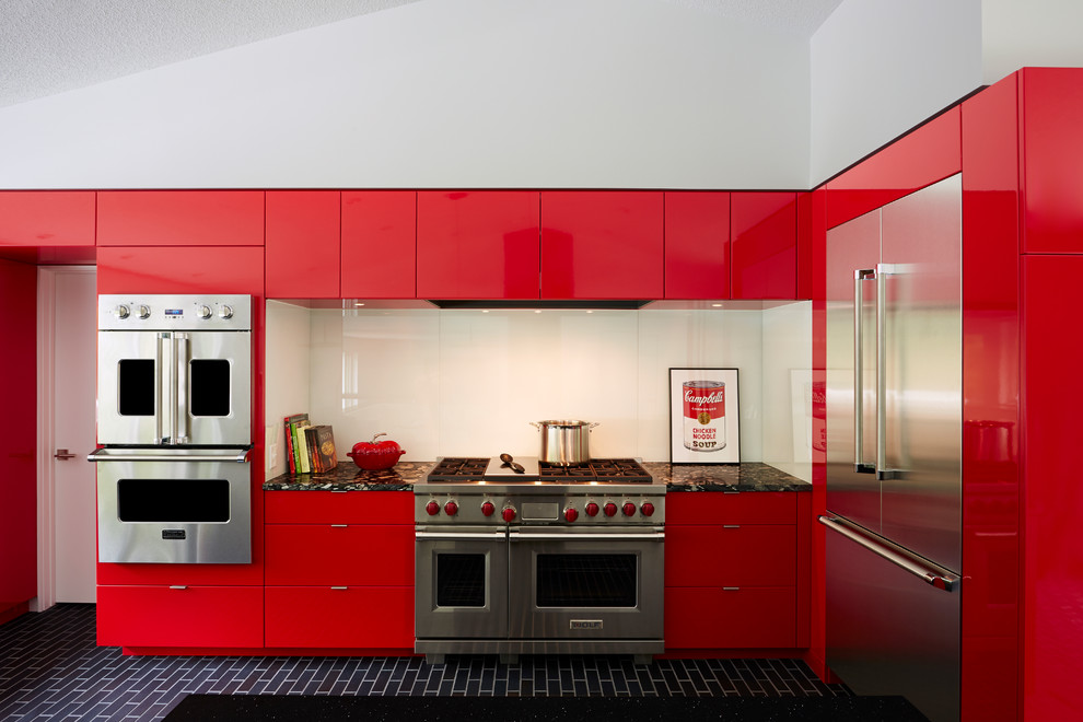 Immagine di una cucina a L minimal con ante lisce, ante rosse, paraspruzzi bianco, paraspruzzi con lastra di vetro e elettrodomestici in acciaio inossidabile