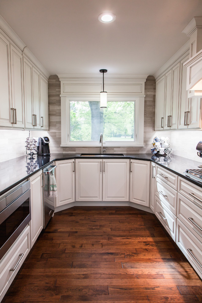 Idéer för att renovera ett stort vintage kök, med en undermonterad diskho, luckor med upphöjd panel, vita skåp, bänkskiva i kvartsit, flerfärgad stänkskydd, stänkskydd i kalk, rostfria vitvaror, mellanmörkt trägolv, en köksö och brunt golv