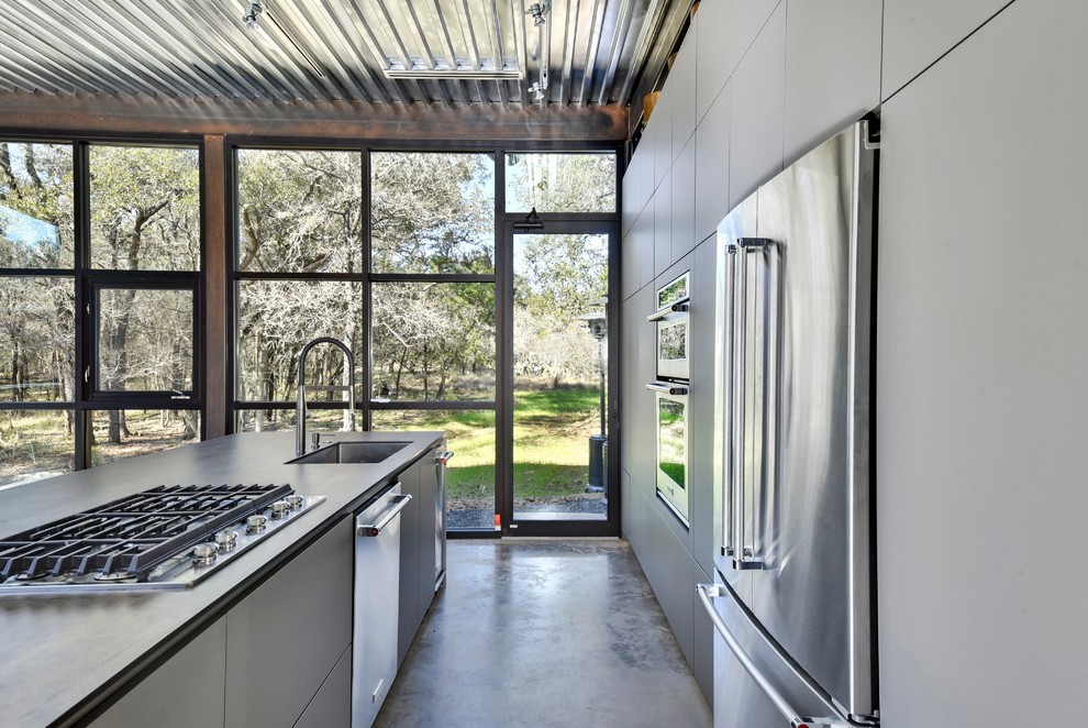 На фото: кухня в стиле лофт с плоскими фасадами и серыми фасадами с