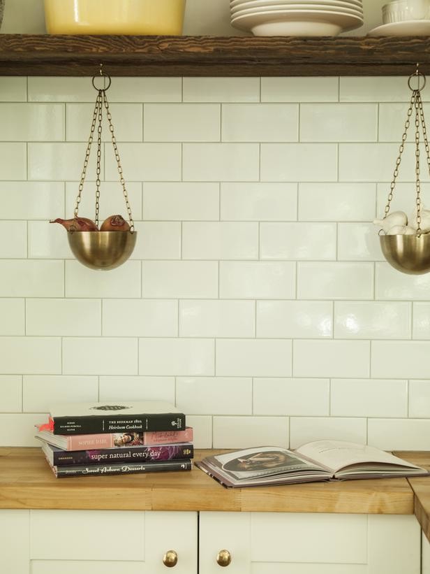 Foto på ett funkis u-kök, med en rustik diskho, släta luckor, vita skåp, träbänkskiva, vitt stänkskydd, stänkskydd i tunnelbanekakel och rostfria vitvaror