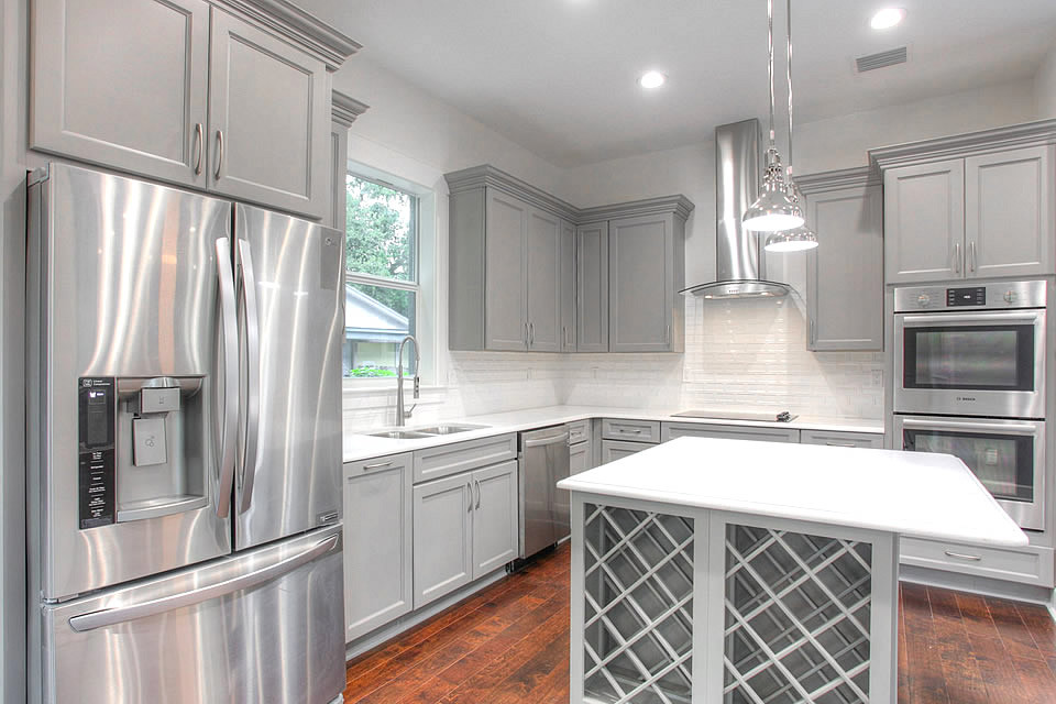 Enclosed kitchen - mid-sized contemporary l-shaped dark wood floor and brown floor enclosed kitchen idea in Tampa with a double-bowl sink, beaded inset cabinets, gray cabinets, quartz countertops, white backsplash, subway tile backsplash, stainless steel appliances and an island