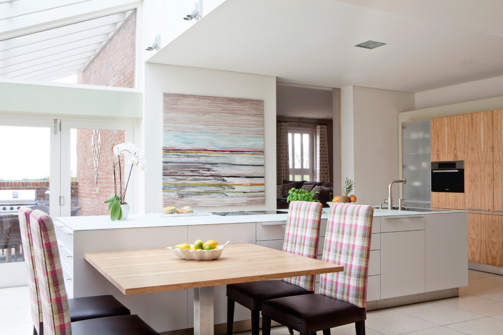 Immagine di una grande cucina abitabile contemporanea con paraspruzzi bianco, top in vetro, ante in legno chiaro, pavimento con piastrelle in ceramica e ante lisce