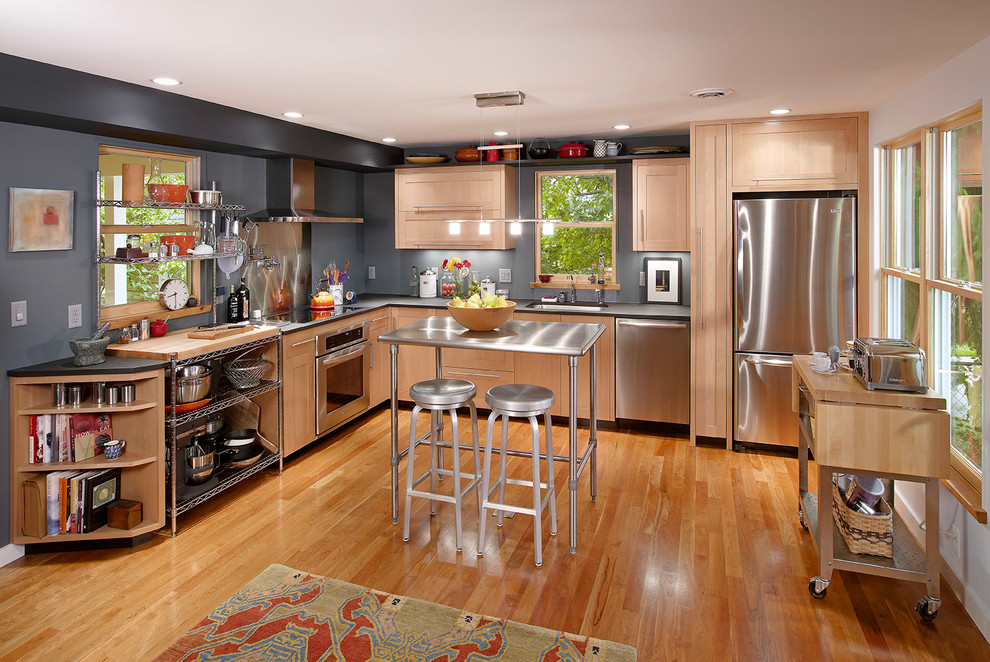 Diseño de cocinas en L contemporánea con electrodomésticos de acero inoxidable, armarios estilo shaker y puertas de armario de madera clara