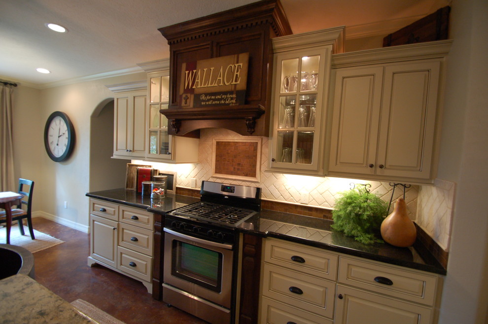 Klassisk inredning av ett litet linjärt kök och matrum, med luckor med upphöjd panel, vita skåp, granitbänkskiva, vitt stänkskydd, stänkskydd i tunnelbanekakel, rostfria vitvaror, betonggolv och en köksö