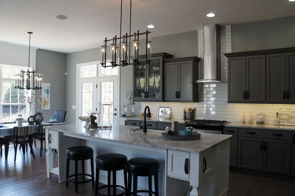 Inspiration for an industrial eat-in kitchen remodel in Cleveland with a farmhouse sink, gray cabinets, quartz countertops, white backsplash, mosaic tile backsplash and stainless steel appliances