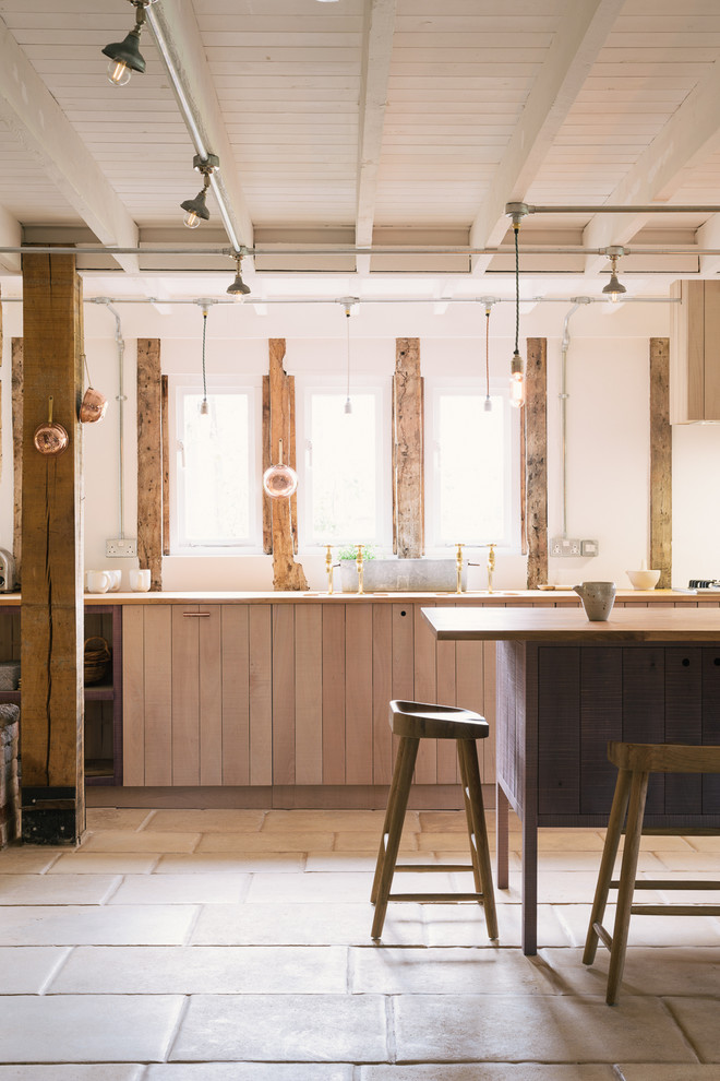 Cette image montre une grande cuisine ouverte linéaire chalet en bois clair avec un évier 2 bacs, un placard à porte plane, un plan de travail en bois et îlot.