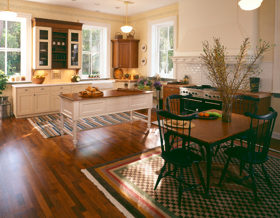 Große Klassische Küche in U-Form mit Landhausspüle, Schrankfronten mit vertiefter Füllung, Elektrogeräten mit Frontblende, dunklem Holzboden und Kücheninsel in New York