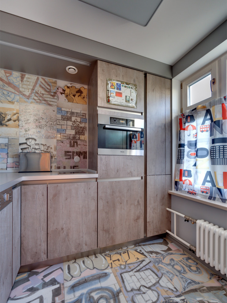 Bild på ett avskilt, litet eklektiskt grå grått l-kök, med en nedsänkt diskho, släta luckor, skåp i mellenmörkt trä, bänkskiva i kvarts, grått stänkskydd, stänkskydd i porslinskakel, klinkergolv i porslin och flerfärgat golv