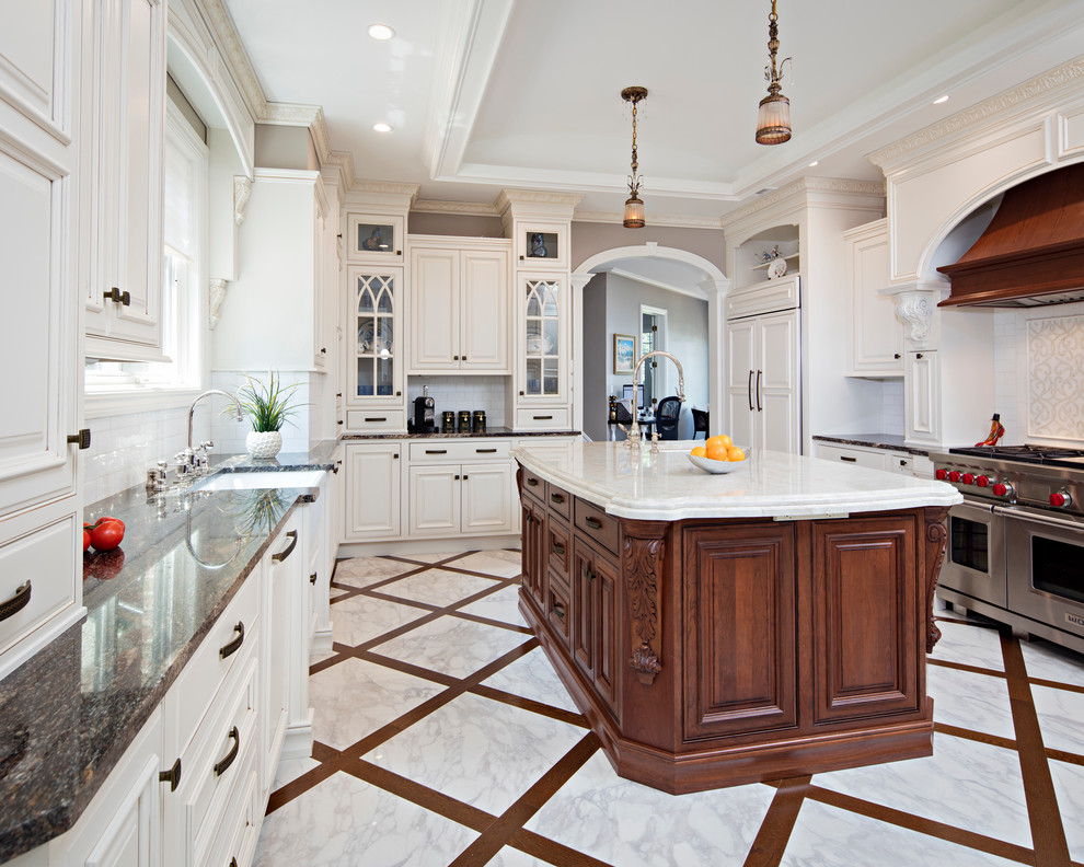 Example of a huge classic l-shaped marble floor kitchen design in New York with an undermount sink, raised-panel cabinets, white cabinets, white backsplash, subway tile backsplash, stainless steel appliances and an island
