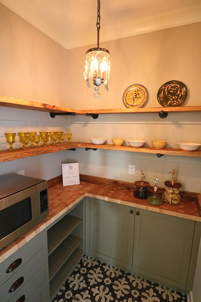 Inspiration för ett litet lantligt kök, med träbänkskiva, rostfria vitvaror, luckor med infälld panel, cementgolv och gröna skåp