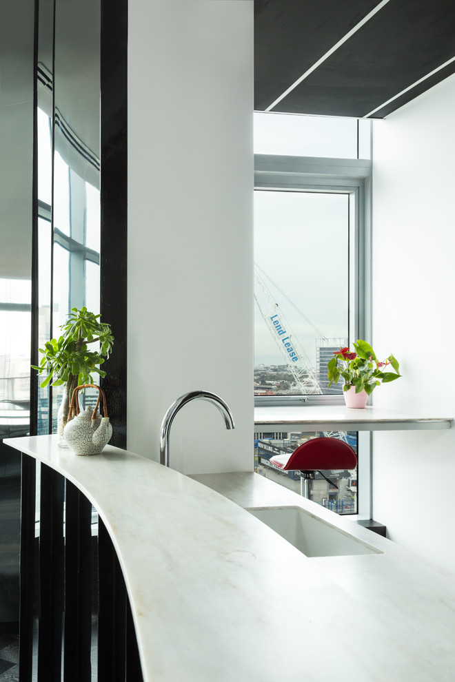 This is an example of a large contemporary u-shaped enclosed kitchen in Melbourne with a submerged sink, dark hardwood flooring, no island, glass-front cabinets, white cabinets, composite countertops, black splashback, metal splashback and black appliances.