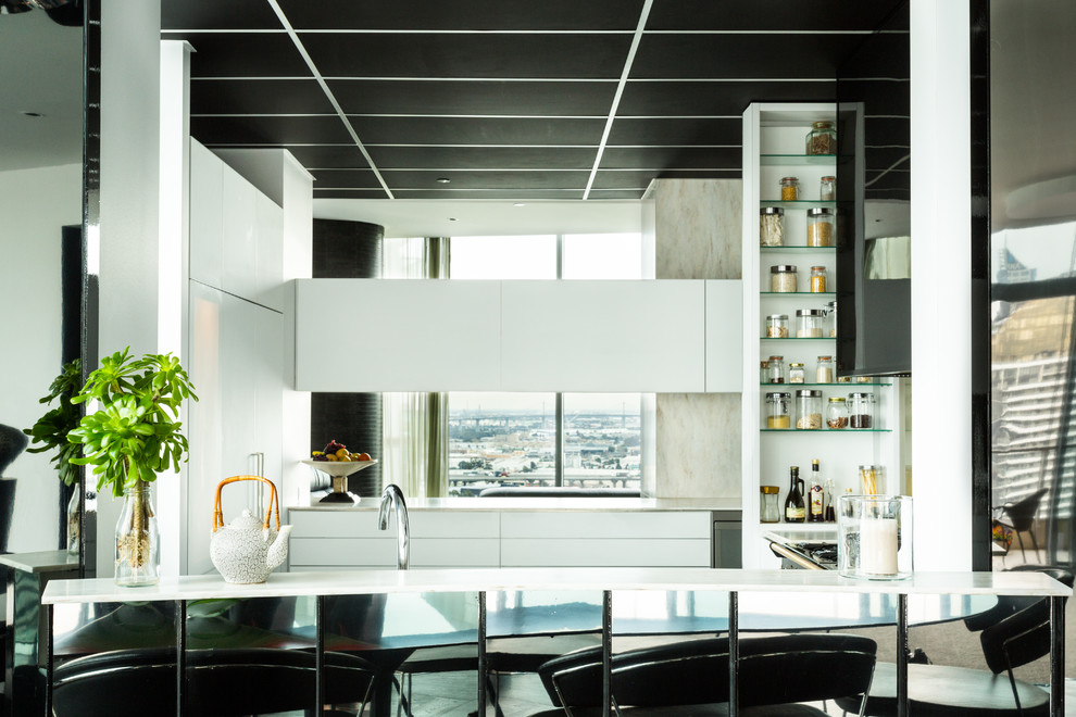 This is an example of a large contemporary u-shaped enclosed kitchen in Melbourne with a submerged sink, dark hardwood flooring, no island, glass-front cabinets, white cabinets, composite countertops, black splashback, metal splashback and black appliances.