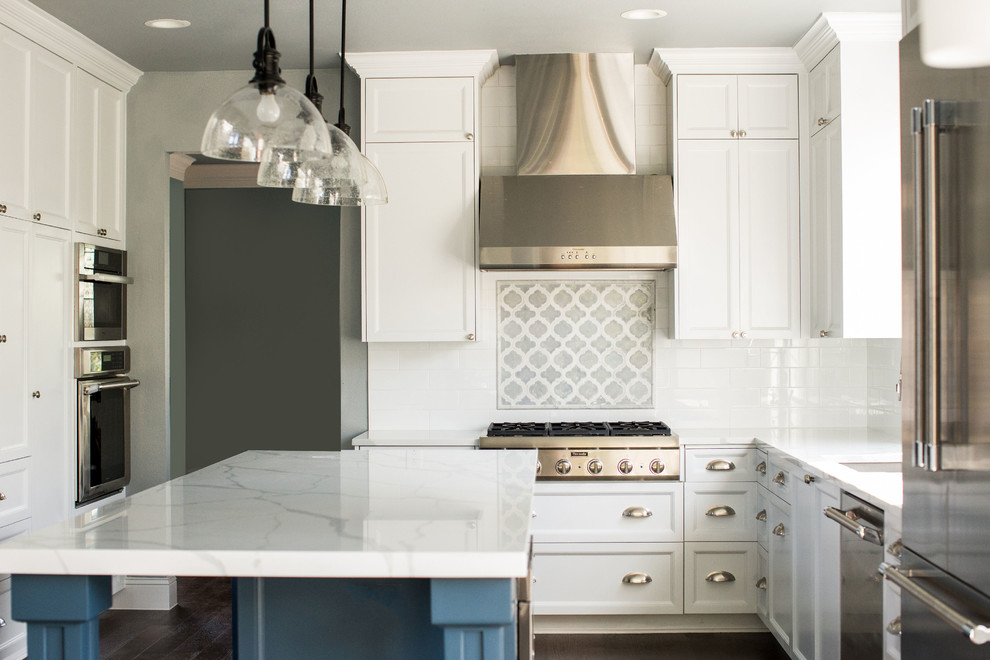 Inredning av ett modernt mellanstort vit vitt kök, med en undermonterad diskho, skåp i shakerstil, vita skåp, vitt stänkskydd, rostfria vitvaror, mörkt trägolv, en köksö, brunt golv, bänkskiva i kvarts och stänkskydd i tunnelbanekakel