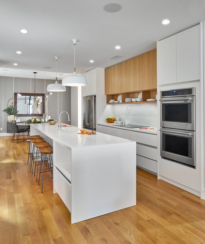Zweizeilige Moderne Küche mit flächenbündigen Schrankfronten, weißen Schränken, Küchengeräten aus Edelstahl, braunem Holzboden, Kücheninsel und braunem Boden in Sonstige