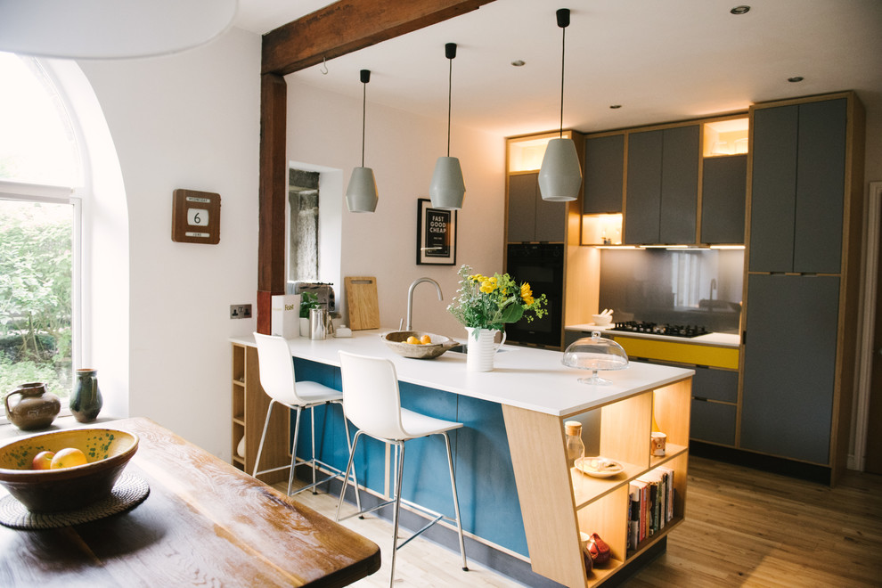 Mittelgroße Moderne Küche mit flächenbündigen Schrankfronten, Küchenrückwand in Grau, hellem Holzboden, Kücheninsel, beigem Boden und weißer Arbeitsplatte in Sonstige
