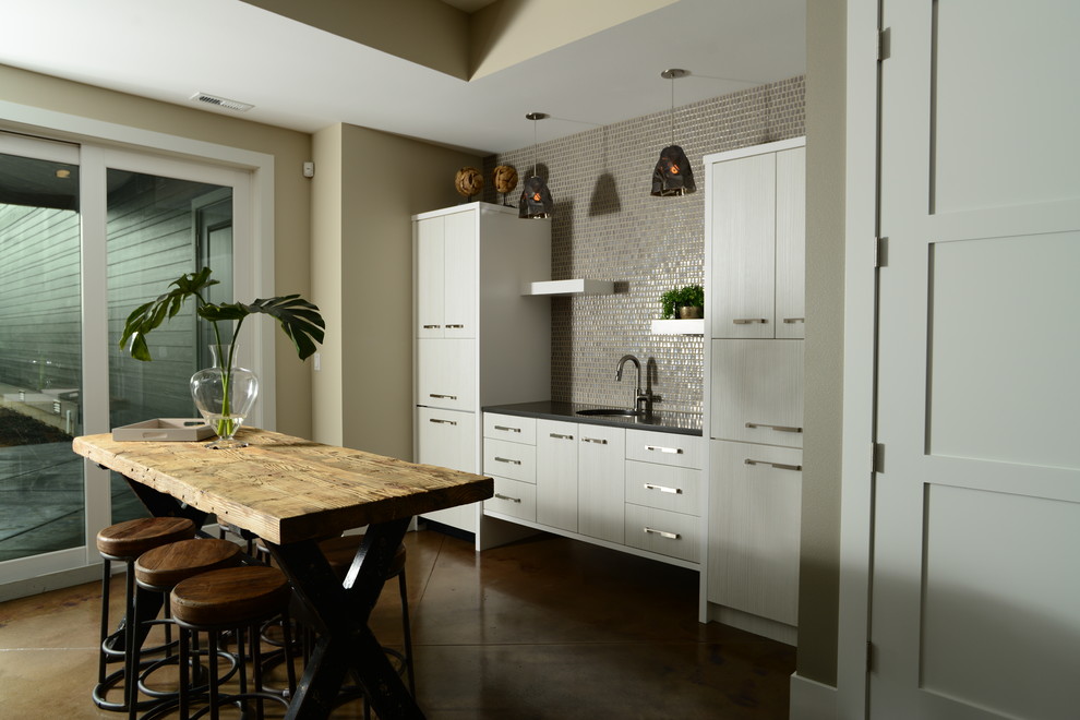 Idéer för att renovera ett litet vintage linjärt kök med öppen planlösning, med en undermonterad diskho, släta luckor, vita skåp, bänkskiva i kvarts, beige stänkskydd, stänkskydd i mosaik och betonggolv