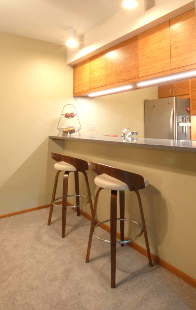 Immagine di una piccola cucina moderna con lavello sottopiano, ante lisce, ante in legno chiaro, nessuna isola e top grigio
