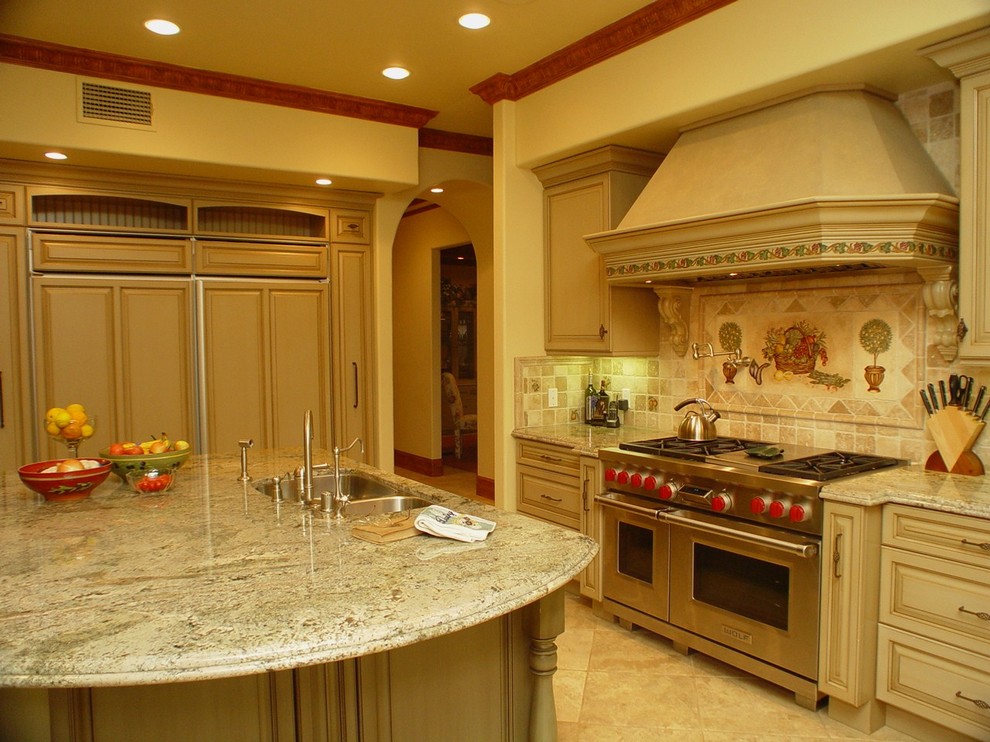 Inspiration for a large mediterranean u-shaped kitchen/diner in Los Angeles with raised-panel cabinets, distressed cabinets, coloured appliances, ceramic flooring and an island.