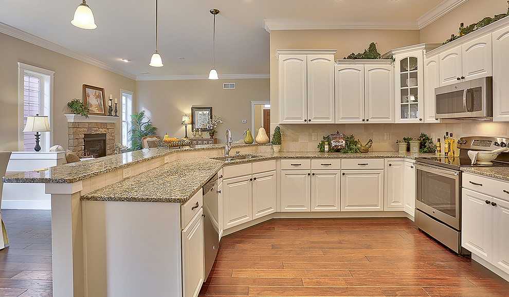 Example of a mid-sized transitional u-shaped dark wood floor eat-in kitchen design in Philadelphia with a double-bowl sink, raised-panel cabinets, granite countertops, beige backsplash, ceramic backsplash, stainless steel appliances, a peninsula and white cabinets
