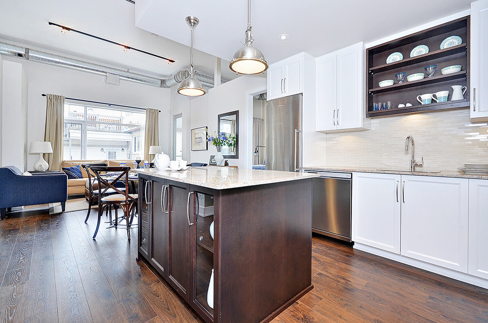 Photo of a small contemporary l-shaped kitchen/diner in Ottawa with a submerged sink, shaker cabinets, white cabinets, granite worktops, beige splashback, stone tiled splashback, stainless steel appliances, dark hardwood flooring and an island.