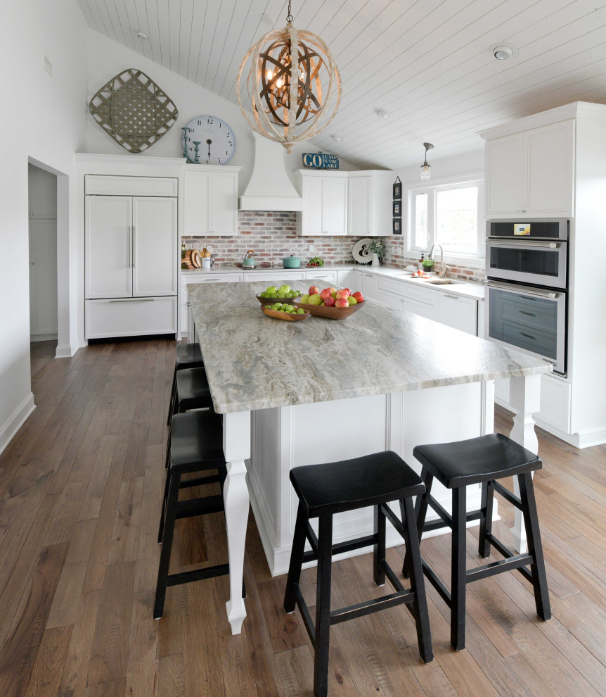 Idéer för att renovera ett stort lantligt grå grått kök, med en undermonterad diskho, luckor med infälld panel, vita skåp, granitbänkskiva, grått stänkskydd, stänkskydd i tegel, integrerade vitvaror, mellanmörkt trägolv, en köksö och brunt golv